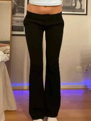 Lågmidjade kostymbyxor - Lågmidjade kostymbyxor från Bikbok! Mycket fint skick. Sömmarna där nere är uppsprättade (har vecklat ut de på bild 3) men det är inget man lägger märke till, går lätt att sys eller pressas! Kontakta om du behöver fler bilder eller mått!