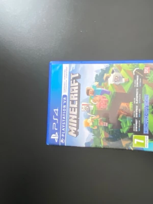 Minecraft PS4 - Minecraft till PlayStation 4 i mycket fint skick. Komplett med fodral, skiva och bonuskod för 700 tokens in-game currency. Fodral och skiva ser ut att vara i nyskick utan synliga repor eller skador. Perfekt för både nya och erfarna spelare.