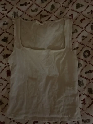 Vit linnetopp från Gina Tricot - Säljer en vit linnetopp från Gina Tricot, kollektionen Basically Basics. Toppen har en fyrkantig urringning och är ärmlös med en normal passform. Perfekt för varma dagar och enkel att matcha med olika stilar.