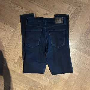 Levi's Line 8 svarta skinny jeans - Svarta skinny jeans från Levi's Line 8 med klassisk femficksdesign, dragkedja och knappstängning. Jeansen har hög midja och smal passform hela vägen ner till ankeln. Materialet är stretchigt jeans för extra komfort och rörelsefrihet.