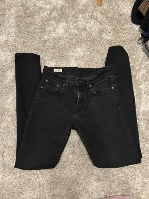 Levi's Premium svarta skinny jeans - Svarta Levi's Premium jeans med klassisk femficksdesign och skinny passform. Jeansen har en mörk tvätt, smal siluett och är tillverkade i stretchigt denim för extra komfort. Levi's logga syns på bakfickan och läderpatchen i midjan. Strl 29/M