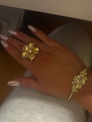 Guldigt Ioaku armband - Jätte fint armband i guld ifrån Ioaku med blomdetaljer! Fick i julklapp julen 2024 men inte kommit till användning så mycket, max 10 gånger. Inga defekter och pris kan diskuteras 🤗Tyvvär är original förpackningen slängd, men kommer packeteras säkert vid beställning. (SKRIV TILL MIG INNAN KÖP NU”