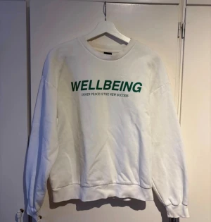 Vit sweatshirt från Gina Tricot - Vit sweatshirt från Gina Tricot med grönt tryck 'WELLBEING' och texten 'INNER PEACE IS THE NEW SUCCESS' på bröstet. Sweatshirt från Gina Tricot i storlek S. Köpt för något år sedan och knappt använd