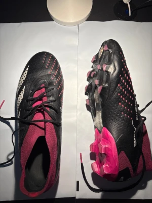 Adidas Predator Elite FG – UK 9 / EU 43⅓ – mycket bra skick - Adidas Predator Elite FG i storlek UK 9 (EU 43⅓). Använda ca 1 månad. Mycket bra skick. Dobbar och sula i fint skick, greppzoner kvar. Endast lätt kosmetiskt slitage där lite färg torkat in – påverkar inte spel. Elite-modellen (högsta nivån). Passar naturgräs (FG).  Nypris ca 3 000 kr.