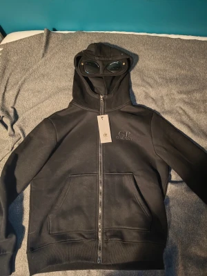 C.P company hoodie svart  - Säljer en helt ny cp company hoodie där taggarna sitter kvar. Jag har inte haft någon användning av den eftersom den var för stor. 