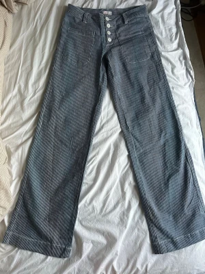 Randiga blå wide jeans med knappar - Jätte fina blå och vita vintage randiga jeans med wide fit och låg midja. Byxorna formar sig efter kroppen och sitter jätte fint. Säljer då de är för små för mig. Skulle säga att de passar de som har S M. Jag är 176 lång så de är lite korta på mig. Perfect skick utan några defekter.