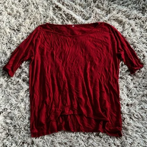 Röd basic topp med korta ärmar  - Enkel röd topp i mjuk bomull med rund halsringning och korta ärmar. Modellen är rak och lite loose, perfekt att styla med jeans eller kjol. Färgen är klar röd och materialet känns lätt och bekvämt mot huden. Extrem stretchig och bekväm. Storlek M