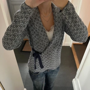 Blå stickad kofta  - Blå mönstrad kofta med snörning från Happy Holly i storlek 36/38. Fint skick. Använd gärna köp nu!