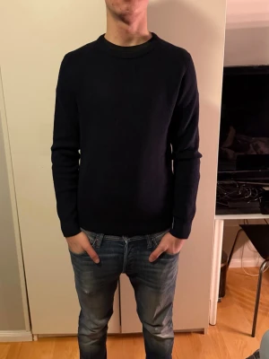 Marinblå stickad tröja från Primark - En marinblå, enkel och stilren stickad tröja från Primark i storlek medium. Tröjan har rund halsringning, ribbade muddar och lång ärm. Perfekt för lager-på-lager under kyliga dagar.