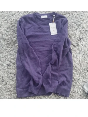 Julklappstips😊 - Säljer en lila stickad tröja från Stenströms i storlek XS. Tröjan är tillverkad i 100% merinoull och har en klassisk rund halsringning samt långa ärmar. Perfekt för dig som gillar mjuka och tunna material med stilren look.