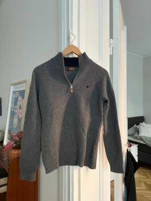 Morris tröja - Snygg grå stickad tröja från Morris med half zip och ribbad krage. Tröjan har ett litet broderat emblem på bröstet och detaljerad dragkedja med läder. Perfekt för dig som gillar klassisk stil med en modern touch. Storlek M men den är liten i storleken så passar S. Den är i väldigt bra skick och mjukt merinoull!!!🙌🙌