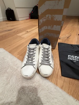 Golden Goose superstar navy/vit - Otroligt fint skick som nya 9.5/10. Använda 3 gånger sparsamt. Tillkommer med box, kvitto dustbag. 