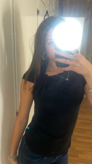 Svart topp med knytdetalj från Zara - Säljer en svart topp från Zara i storlek xs. Toppen har korta ärmar och dragkedja i sidan🥳