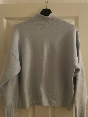 Ljusblå polotröja från Gina Tricot - Mjuk och stilren ljusblå polotröja från Gina Tricot i storlek S. Tröjan har en hög ribbad krage, långa ärmar och breda ribbade muddar vid ärmslut och nederkant. Endast använd ett fåtal gånger ❤️