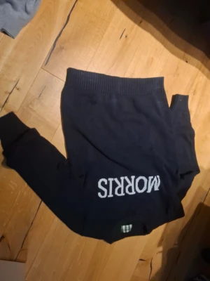 Mörkblå stickad tröja Morris - Snygg mörkblå stickad tröja från Morris med vit logga på bröstet. Tröjan har rund hals, ribbade muddar vid ärmslut och nederkant samt långärmad passform. Perfekt för dig som gillar klassisk stil med en modern touch.