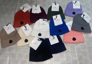 Moncler ribbade mössor i olika färger - Säljer snygga ribbade mössor från Moncler i flera färger som beige, vinröd, blå, rosa, grå, svart, lila, olivgrön och vit. Mössorna har uppvikt kant och Moncler-logga framtill. Perfekt accessoar för att hålla stilen och värmen.