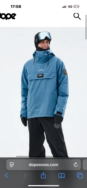 Blå skidjacka från Dope Snow - Snygg blå vindjacka från Dope Snow med hög krage, stor ficka framtill och justerbar huva med snörning. Använd endast 1 vecka