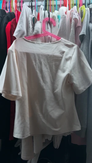 Vit croppad blus med knappar - Säljer en vit blus från 157 i croppad modell med korta ärmar och v-ringning. Toppen har tre snygga knappar framtill och är gjord i mjuk bomull. Perfekt för dig som gillar enkel och clean stil med lite edge.