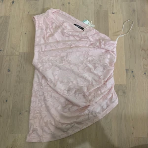Ljusrosa asymmetrisk topp Gina Tricot - Säljer en ljusrosa topp från Gina. Helt i nyskick, den har bara inte kommit till använding.