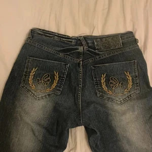 vintage jeans med broderade fickor💕 - Säljer dessa coola vintage jeans som jag köpte i london då de är lite små på mig. Broderade med guldtråd på backfickorna. Skriv bara om du har fler frågor om mått eller bilder. De är knappt använda❤️från märket age wash jeans💕pris kan diskuteras
