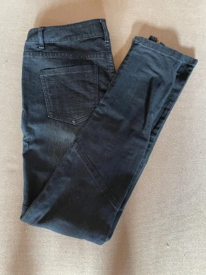 Mörkblå jeansbyxor med dragkedjor - Snygga mörkblå jeansbyxor från Cubus med coola dragkedjor vid fickorna och bensluten. Byxorna har raka ben, normal passform och är tillverkade i jeansmaterial. Perfekt för dig som gillar detaljer och en stilren look.