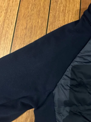 Mörkblå pufferjacka från North Bend - Snygg mörkblå pufferjacka från North Bend med quiltad framsida och slät baksida. Jackan har långärmade ärmar, dragkedja framtill och sportig look. Perfekt för kyliga dagar och har en clean design utan mönster eller extra detaljer.