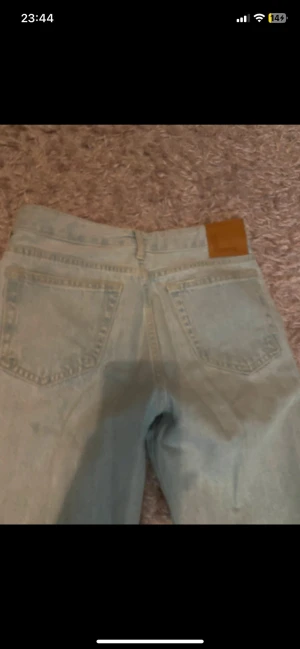 Blå bootcut jeans - Säljer ett par ljusblå bootcut jeans från Never Denim/ Carlings, med klassisk femficksdesign och raka ben. Lågmidjade och sitter snyggt och tight, mycket bra skick knappt använda ☺️
