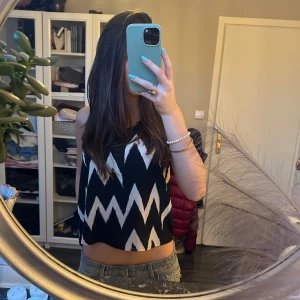 Topp - Säljer en snygg linnetopp med svartvit zigzag-mönster. Toppen är ärmlös och har en loose passform som ger en chill vibe. Aldrig använd! Skriv privat vid frågor💕