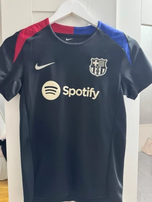 Nike FC Barcelona Dri-Fit tröja XS - Säljer en svart FC Barcelona fotbollströja från Nike med Dri-FIT material. Tröjan är använd ett fåtal gånger och är i fint samt bra skick.