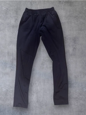 SOC träningsbyxor  - Snygga och bekväma träningsbyxor från SOC i mörkblå färg. Tillverkade i tekniskt funktionsmaterial med Airflow-system som transporterar bort fukt och håller kroppen torr och bekväm. Perfekta för idrott, träning eller fritid.