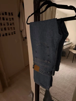 Straight jeans från Pull&Bear, blå - Säljer ett par blå straight jeans från Pull&Bear i klassisk denim. Modellen har raka ben och en snygg bakficka med detalj i brunt. Orkade aldrig lämna tillbaka byxorna. Men dom är bara testade & inte använda. 