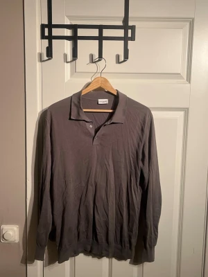 Brun långärmad pikétröja John Henric - Säljer en stilren grå långärmad pikétröja från John Henric i storlek M. Om du har mer frågor eller vill se mer bilder är det bara att fråga