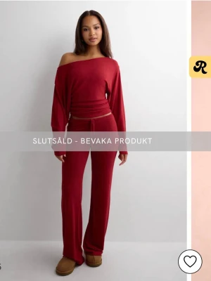 Röd slutsåld sett - En offshoulder topp med ett par mjuka lågmidjade byxor till. Prislapp finns kvar så helt nya