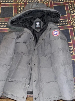 Äkta Canada Goose jacka för män (Carson Parka, storlek XS) - Storlek XS, använd i 1 vinter. Nyskick. Köpt från Johnells så digitalt kvitto finns vid efterfrågan. Säljs utan päls.
