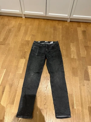 Svarta slim jeans Jack & Jones - Slim Glenn jeans från Jack & Jones i svart tvättad denim. Klassisk femficksmodell med knapp och dragkedja i midjan. Snyggt smal passform och raka ben, perfekt för dig som gillar en stilren look.
