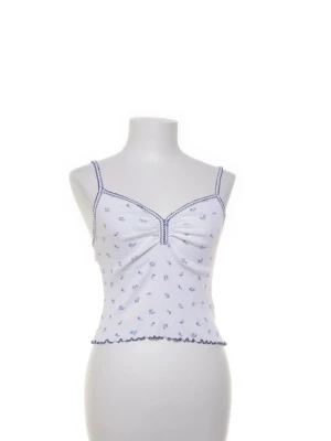 Vit blommig linnetopp från BDG - Supersöt vit linnetopp från BDG Urban Outfitters i storlek S. Toppen har blå små blommor, ribbad struktur och blå vågig kant nedtill. Materialet är väldigt stretchigt och har fin passform. Passa på!💗