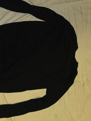 Svart merinoullströja från Vailent - Säljer en svart långärmad tröja från Vailent i mjuk merinoull. Tröjan har en klassisk rund hals och är enkel i designen, perfekt för dig som gillar stilrena plagg. Passar dig som vill ha en skön och tidlös look.