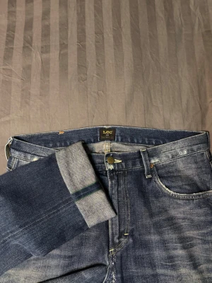Lee 101 green selvage slim fit - Tja säljer dessa brutalt sjuka lee jeasen. De kommer från Lee 101 vilket är deras perium line. Jeansen är i green japanskt vävd selvage. 12 ounces 10 dips. Modellen heter rider och de sitter slim fit. Storleken är lite oklar så gå gärna efter måtten, 43 cm midja 110 cm ytterbenslängd. Har en lagning i skrevet som syns på sista bilden.
