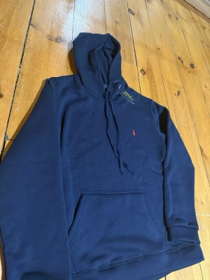 Polo ralph lauren hoodie  - Säljer en hoodie från polo Ralph lauren med en diskret röd loga på bröstet. Passar dig som vill ha en stilren stil storlek m men passar s hör av er för funderingar.