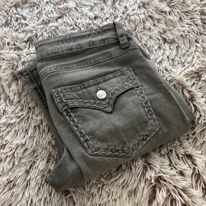 Grå jeansbyxor från Gina Tricot - Snygga grå jeansbyxor från Gina Tricot med raka ben och coola detaljerade sömmar på bakfickorna. Klassisk femficksmodell med dragkedja och knapp framtill. Perfekta för dig som gillar en avslappnad men trendig look.