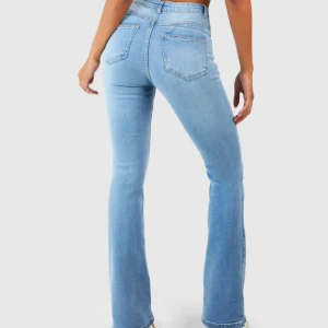 Ljusblå bootcut jeans med hög midja - Snygga ljusblå jeans med bootcut-ben och hög midja. Jeansen har klassiska bakfickor och är tillverkade i mjukt denimtyg som sitter skönt. Perfekta för dig som gillar en retroinspirerad look med moderna vibbar. Sitter jätte bra i rumpan men är för stora för mig därför säljer💕