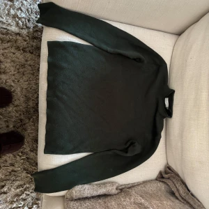 Mörkgrön tröja från Primark XS - Mörkgrön tjocktröja från Primark i enkel och stilren design. Tröjan har lång ärm och en lite högre krage som ger en clean look. Perfekt att styla med jeans eller kjol för en chill vibe. Materialet är mjukt och känns skönt mot huden.