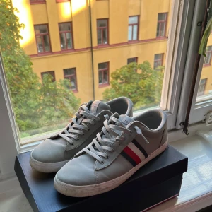 Tommy Hilfiger skor - Grå Tommy Hilfiger skor/sneakers. Nån liten fläck på sulan som enkelt tvättas bort, Inga defekter på skorna 👟 Skick 8/10                   Allt OG ingår,  Köpta för cirka 500kr - Mitt pris 399kr, Kan sänka vid snabb affär - Hör av er vid minsta fråga eller fundering.