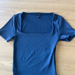 Mörkblå Crop topp  -  mörkblå crop topp från Amisu/ NEW YORKER i storleken S.  Med korta ärmar och trendig fyrkantig ringning. Toppens material är mjukt och stretchigt. Använd, men har bra skick.