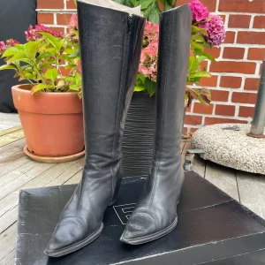 Svarta höga skinnstövlar med klack - Säljer ett par svarta stövlar från Bianco i äkta skinn. De har spetsig tå, medelklack och dragkedja på insidan. Köpta på 90-talet. 