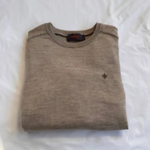 Beige stickad tröja från Morris - Snygg beige stickad tröja från Morris i 100% merinoull. Tröjan har rund halsringning och en liten broderad logga på bröstet. Perfekt för dig som gillar stilrena och klassiska plagg med en modern touch. Nypris: 1400kr✅💯