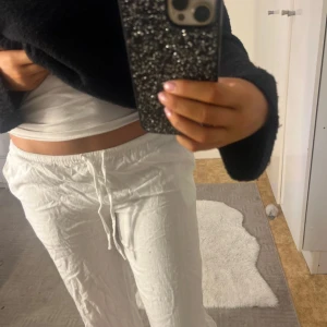 Vita linnebyxor med snörning - Säljer ett par vita linnebyxor med avslappnad passform och snörning i midjan. Byxorna är lätta och luftiga, perfekta för varmare dagar. De har raka ben och en enkel, stilren look som funkar till många outfits. Har en liten fläck som inte syns om man inte kollar nära (se sista bilden)