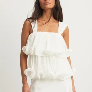 volangtopp NA-KD - Superfin vit topp från Lojsans kollektion med NA-KD. Använd en gång. Köpt för 499kr🥰Säljer för 370kr/högst bud!