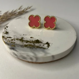 Rosa fyrklöver örhängen med guldfärg - Supersöta örhängen i form av fyrklöver med rosa mitt och detaljerad guldfärgad kant. Perfekta för att ge din look en färgklick och lite extra charm. Säljs som ett par.