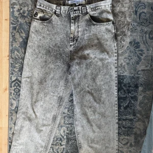 Polar Skate Co Big Boy Acid Black Jeans - Säljer ett par Polar Skate Co Big Boy jeans i acid black tvätt. De har loose passform, raka ben och klassiska femficksdetaljer. Jeansen är tillverkade i kraftig bomullsdenim och har en tydlig acid wash-look som ger en riktigt streetig vibe.